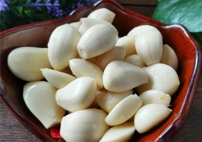 Dùng mặt phẳng cứng để bóc tỏi Dùng mặt phẳng cứng để bóc tỏi